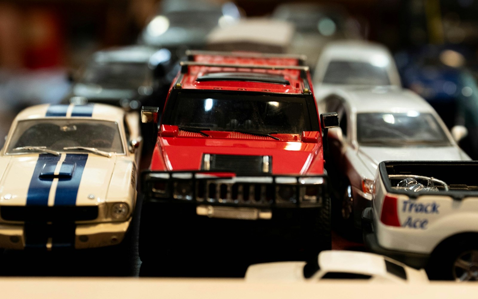 Die-cast toy cars in a row with a red truck at the centre